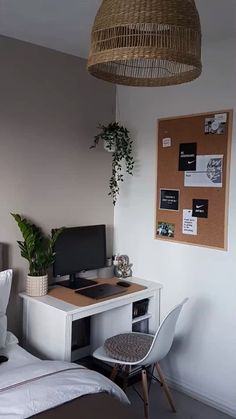 a bedroom with a bed, desk and computer on the table in front of it