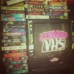 an old television sitting in front of a pile of dvds