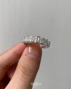 a person holding a diamond ring in their hand