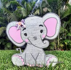 an elephant is sitting in the grass with a flower on its head and it's trunk