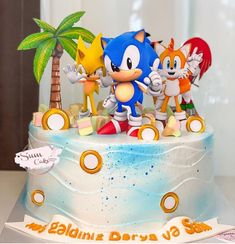 a birthday cake with sonic the hedgehog figures on top and other characters around it