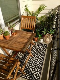 a table and chairs on a balcony with potted plants