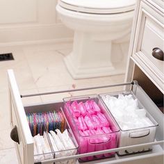 the drawers are filled with different types of toilet paper and other items for storage in this bathroom