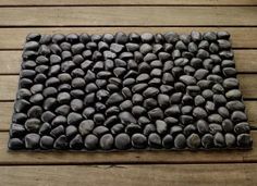 a mat made out of rocks on top of a wooden floor