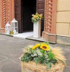 a basket with sunflowers and greenery in front of a church entrance door