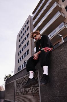 a man sitting on the side of a building