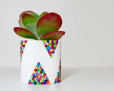 a potted plant is made out of legos and has a colorful geometric design on it