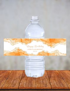 a water bottle label that says happy birthday with an orange and white swirl design on it