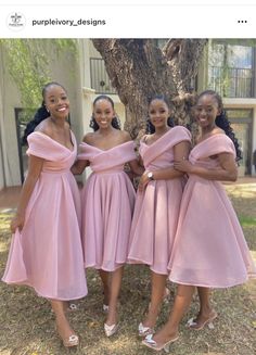 three women in pink dresses standing next to each other with their arms around one another