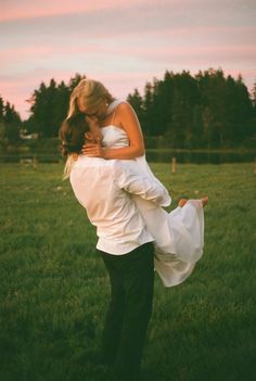 a man and woman are hugging in a field