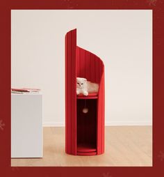 there is a red shelf with a white cat in it