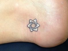 a small tattoo on the foot of a woman's left leg, with an interlocked star