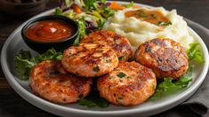 a white plate topped with meat patties, mashed potatoes and veggies