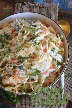 a bowl filled with coleslaw and carrots on top of a wooden table