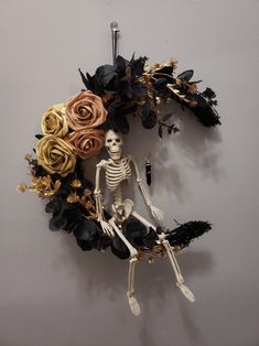 a skeleton sitting on top of a flower wreath