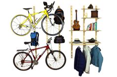 there is a bike, backpack and coat rack in the room with bookshelves