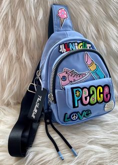 "Beautiful Light Blue nylon sling bag, crossbody, backpack, handbag with three pockets. Two large silver zipper pockets and one small magnetic snap pocket. Inside there is a zipper pocket and also an open pocket. A thick black adjustable strap and detailed with fun & fabulous colorful patches.  8\"L, 6\"W, 10\"H 23\"- 43\" Adjustable strap TheShellBellBags are my designs and each handbag is one-of-a-kind and uniquely handcrafted with all embellishments carefully being hand applied. Each handbag is beautifully detailed with bold style for the fashion conscious woman." Trendy Blue Shoulder Chest Bag, Back To School Crossbody Shoulder Bag, Trendy Blue Chest Bag For School, Trendy Blue Chest Bag With Adjustable Strap, Trendy Blue Crossbody Chest Bag, Trendy Chest Bag Backpack With Zipper Pocket, Blue Crossbody Backpack With Removable Pouch, Blue Shoulder Chest Bag With Zipper Closure, Blue Crossbody School Backpack