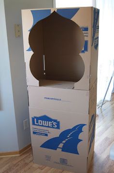 a cardboard box sitting on top of a hard wood floor next to a white wall