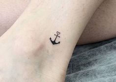 a small anchor tattoo on the ankle is shown in black ink, with an arrow at the center