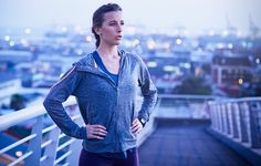 a woman standing on top of a roof with her hands on her hips and looking off into the distance