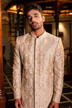 Pearl beige raw silk sherwani with all over hand embroidery, French knot detailing and mandarin collar. Paired with kurta and churidar.
Component: 3
Pattern: Hand Embroidered
Neckline: Mandarin Collar
Sleeve Type: Full Sleeves
Fabric: Raw Silk
Color: Beige
Other Details: 
Front concealed closure on sherwani
Occasion: Wedding,Destination Wedding - Aza Fashions Beige Raw Silk Sherwani With Dabka, Ceremonial Raw Silk Sherwani With Naqshi, Eid Raw Silk Sherwani With Intricate Embroidery, Ceremonial Naqshi Sherwani In Raw Silk, Eid Sherwani With Intricate Embroidery In Raw Silk, Raw Silk Bandhgala With Resham Embroidery, Traditional Bandhgala For Reception During Diwali, Raw Silk Sherwani With Intricate Embroidery For Reception, Fitted Raw Silk Sherwani With Naqshi Details