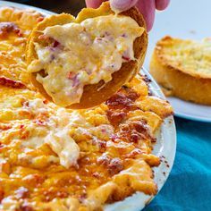 a person dipping some food on top of a pizza