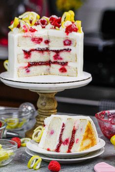 two slices of cake on plates with raspberries and lemons