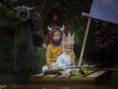 two children dressed up in costumes sitting on a crate