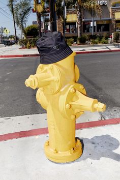 a yellow fire hydrant with a black hat on top