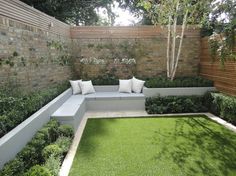 an outdoor seating area with grass and bushes