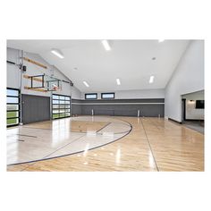 an indoor basketball court with hard wood flooring and glass doors leading to the upper level