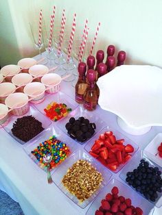 a table topped with lots of desserts and cups filled with candies on top of it