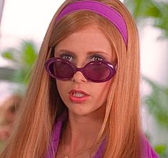 a woman with long red hair wearing sunglasses