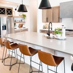 a kitchen with an island and four bar stools