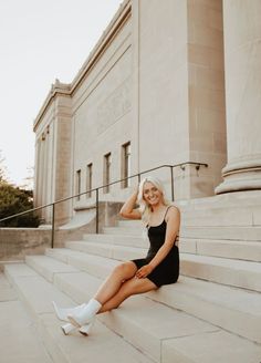 a woman sitting on steps in front of a building