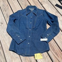 New with tags! Still in excellent condition with no flaws. It's the perfect 70's western snap shirt. Thicker denim feel. Measures 18.5" pit to pit, 26.5" nape to hem, 14.5" shoulder to shoulder and 23.5" shoulder to cuff. Fits like an xs. Western Style Medium Wash Shirt For Rodeo, Vintage Medium Wash Tops For Rodeo, Vintage Denim Top For Rodeo, Western Style Fall Tops With Snap Buttons, Fall Western Tops With Snap Buttons, Dark Wash Long Sleeve Shirt For Rodeo, Fitted Medium Wash Shirt With Buttons, Fitted Denim Shirt With Buttons, Western Snap Button-up Tops