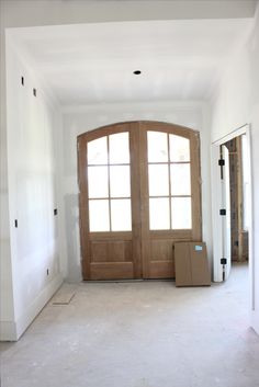 an empty room with two open doors and boxes on the floor