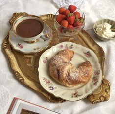 there is a pastry on the plate and bowl of strawberries