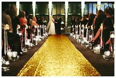 the aisle is lined with candles and people are sitting down to their wedding ceremony at night