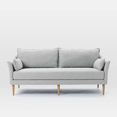 a gray couch sitting on top of a white floor