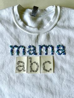 a white t - shirt with the word mama on it