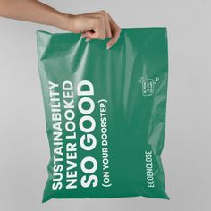 a person holding a green bag with the words, never looked good on it's side