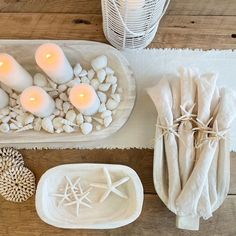 candles and seashells are displayed on the table