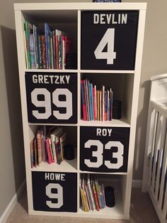 a book shelf filled with books next to a baby crib