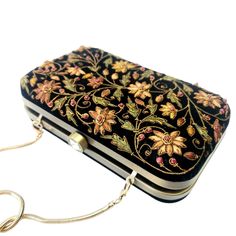 "Beautiful designer luxury black velvet hard case clutch bag, hand embroidered with a rich palette of caramel colored flowers and embellished with ruby gemstones. This will be your go to purse for any wedding! A classic design that never goes out of style. Expertly hand embroidered by third generation zardozi artisans. The word Zardozi means \"gold thread\". It is an elaborate and intricate multidimensional embroidery using metallic threads and genuine precious and semi precious gemstones. A cen Bride Purse, Velvet Clutch Bag, Embellished Purses, Flowers Luxury, Floral Handbags, Velvet Clutch, Types Of Gifts, Wedding Purse, Wedding Clutch