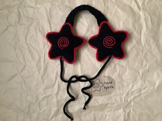 a crocheted headband with two flowers attached to it on a white sheet