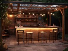 an outdoor bar is lit up at night with lights on the ceiling and stools