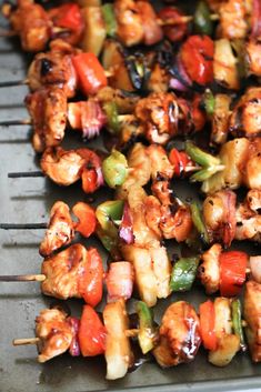 skewers of chicken and vegetables are being cooked on a bbq griddle