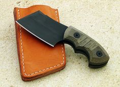 a knife sitting on top of a leather case