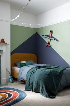 a bedroom decorated in green, blue and orange with a bed that has a blanket on it